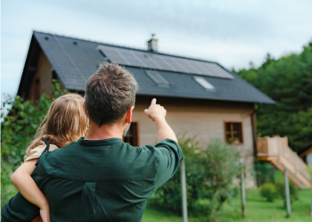 父亲和女儿看着屋顶上的太阳能电池板